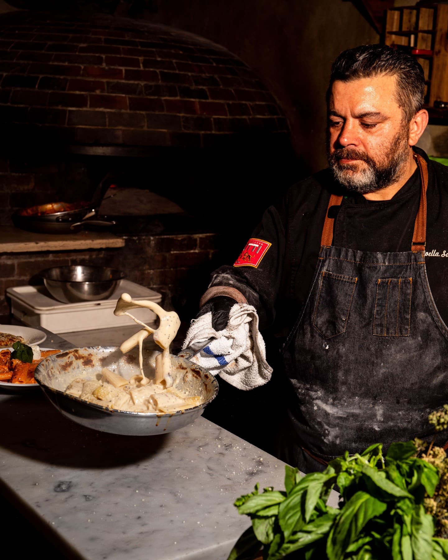 Salvatore Olivella stretching fresh mozzarella over a bowl